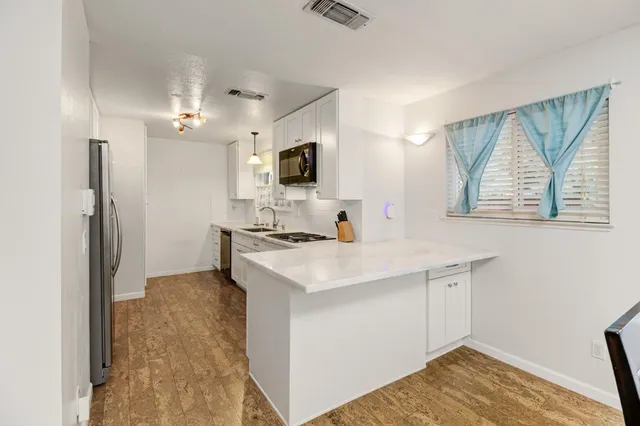 a kitchen with stainless steel appliances granite countertop a refrigerator and a sink