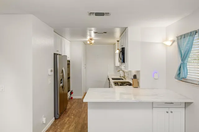 a kitchen with stainless steel appliances a sink a stove a microwave and cabinets