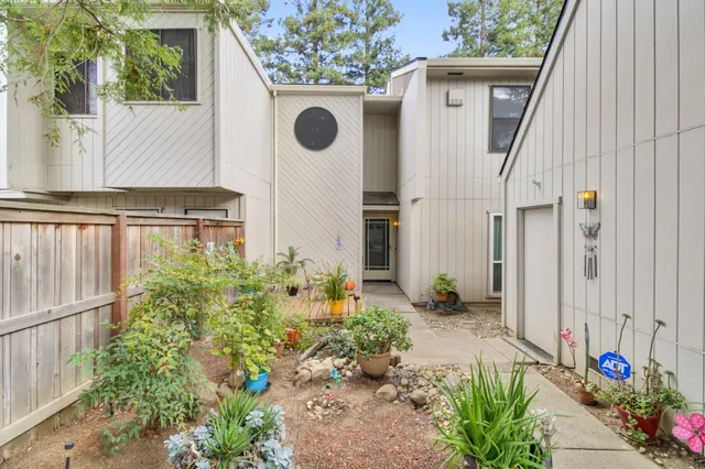 a view of a house with wooden fence next to a yard