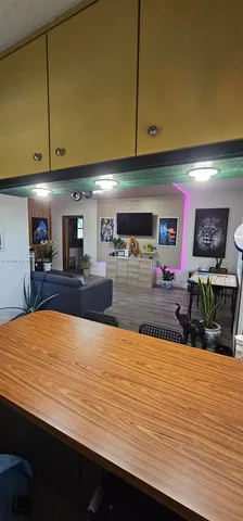 a kitchen with stainless steel appliances wooden floor and a refrigerator