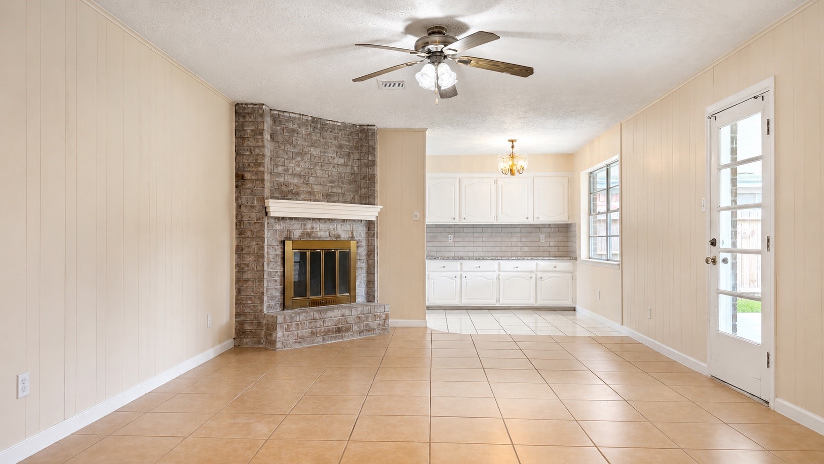 4418 Ponca Street Pasadena, TX 77504 - Photo 10 of 23 Main living area with tile floors, ceiling fan, and a classic brick fireplace. (image has been enhance for marketing purposes)