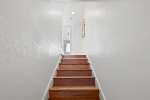 a view of a hallway with wooden floor and closet