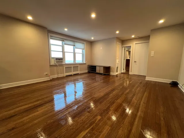 a view of empty room with wooden floor