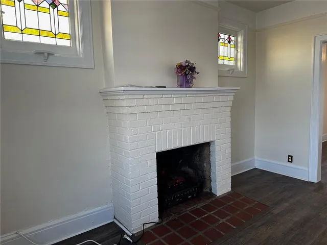 a view of an empty room with a fireplace and a window