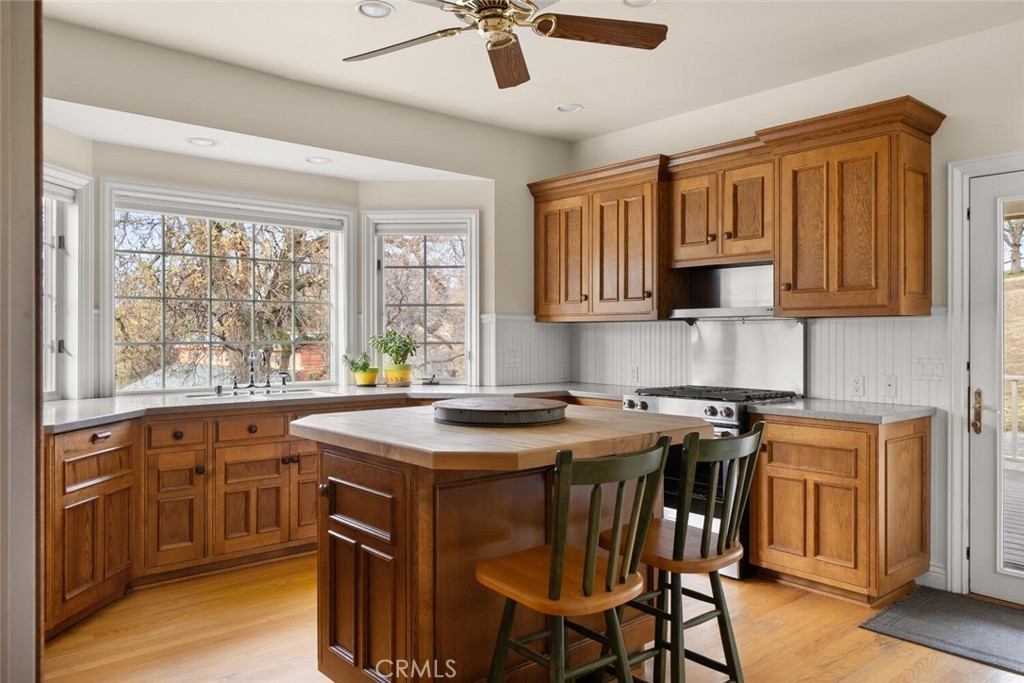 3576 Dry Creek Road Oroville, CA 95965 - Photo 19 of 75 a kitchen with stainless steel appliances granite countertop a stove a sink dishwasher a microwave oven with a dining table and chairs with wooden floor