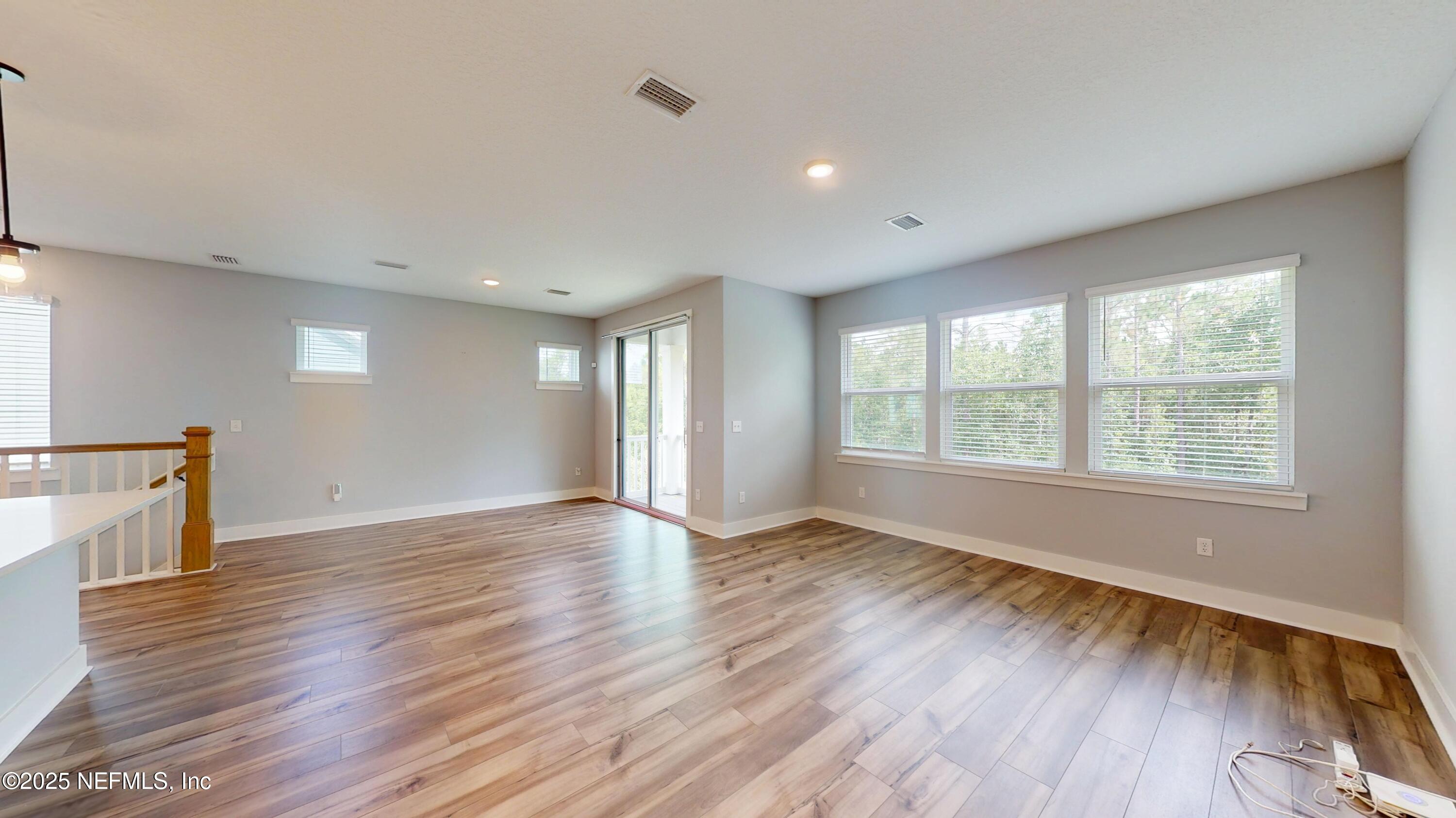 9921 Element Road Jacksonville, FL 32256 - Photo 13 of 37 a view of an empty room with wooden floor and a window