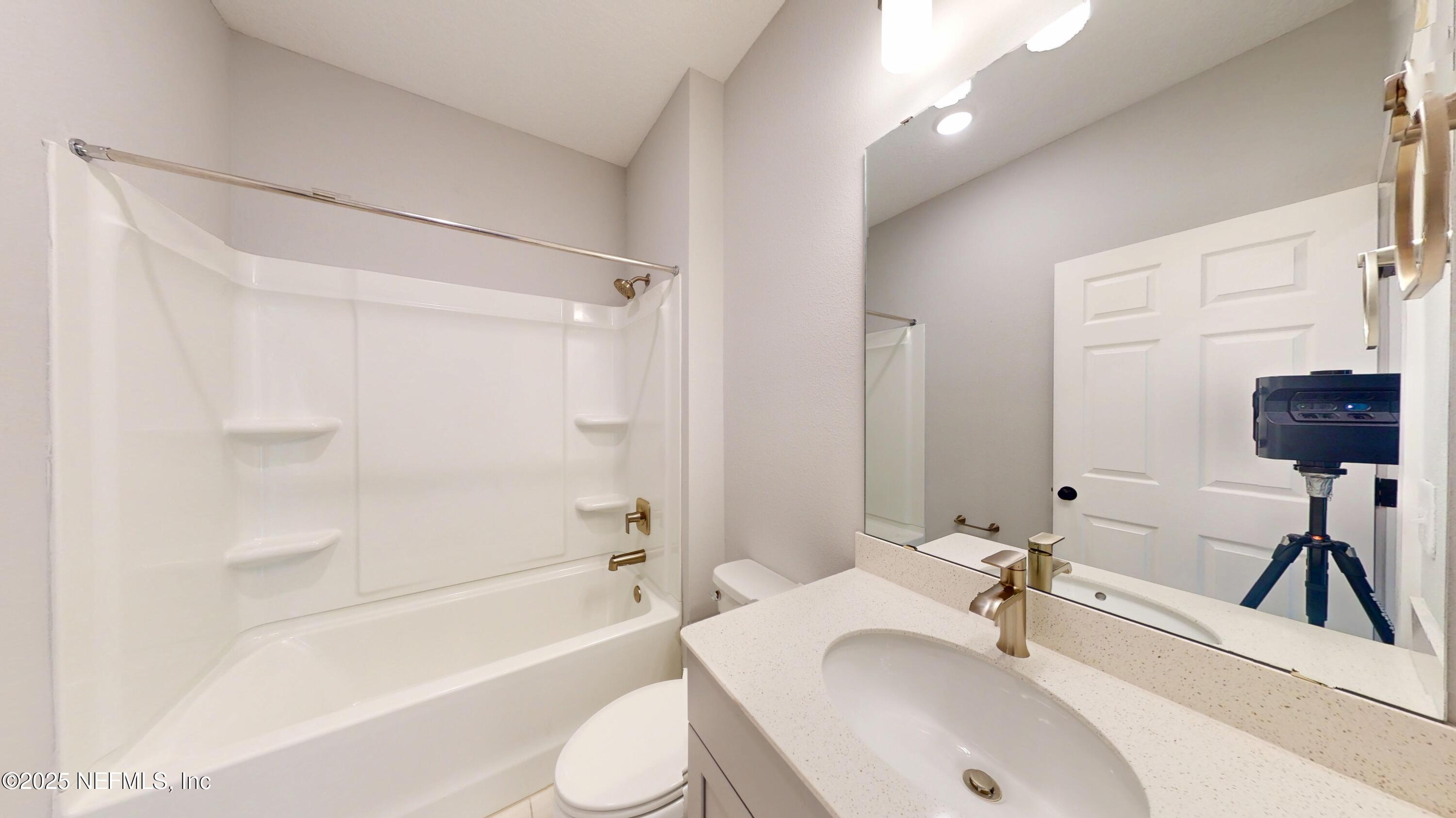 9921 Element Road Jacksonville, FL 32256 - Photo 16 of 37 a bathroom with a sink a toilet and shower