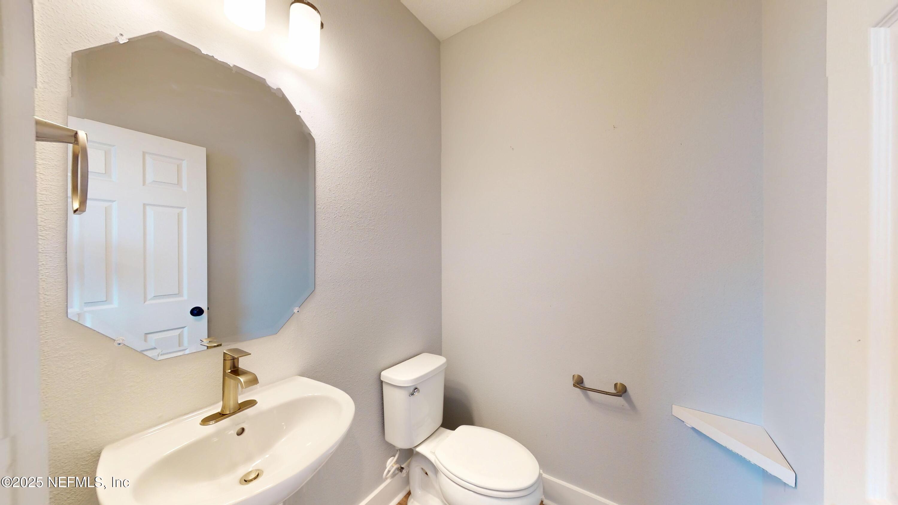 9921 Element Road Jacksonville, FL 32256 - Photo 20 of 37 a bathroom with a sink a toilet and mirror