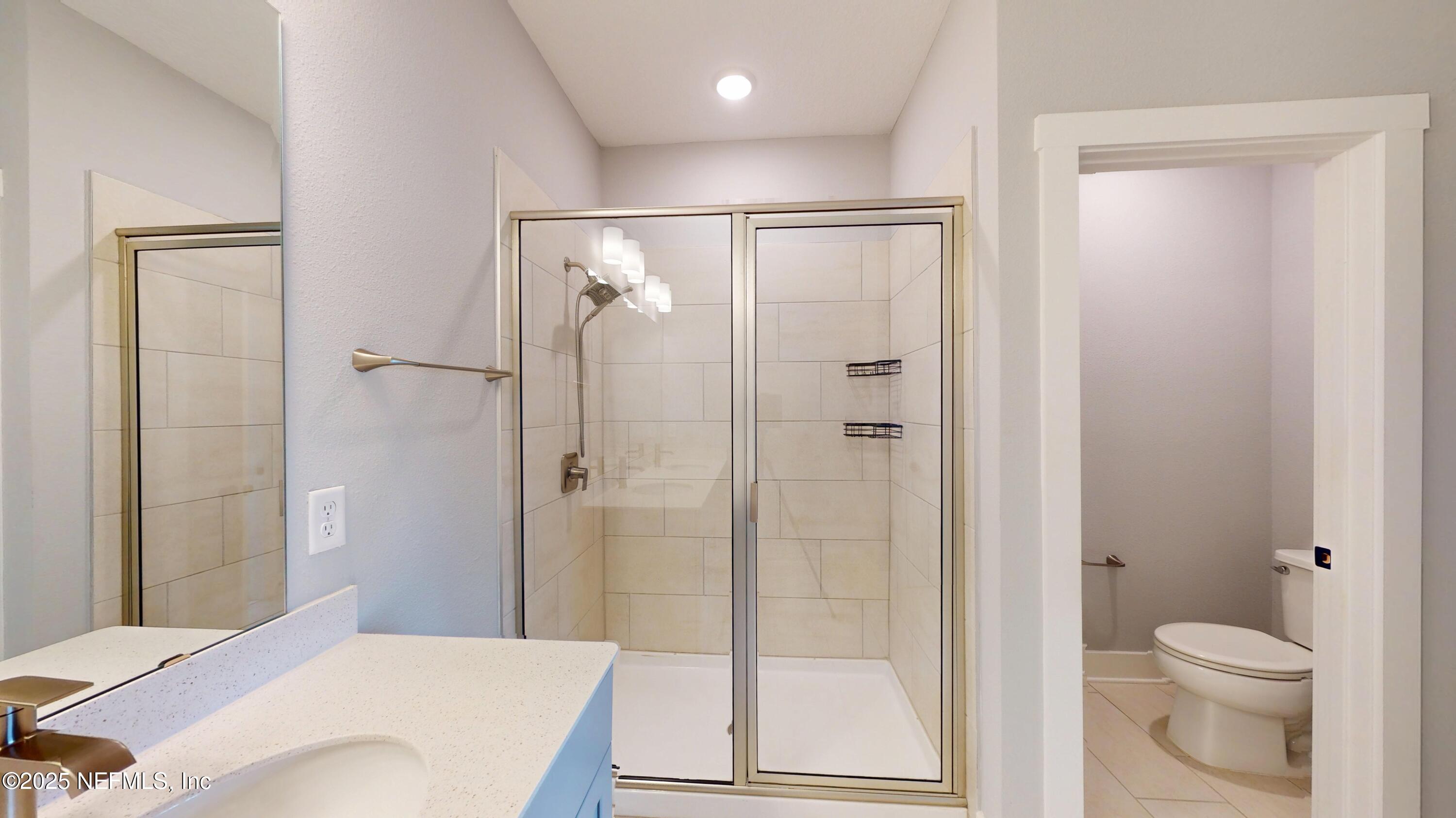 9921 Element Road Jacksonville, FL 32256 - Photo 25 of 37 a bathroom with a shower a toilet and a sink