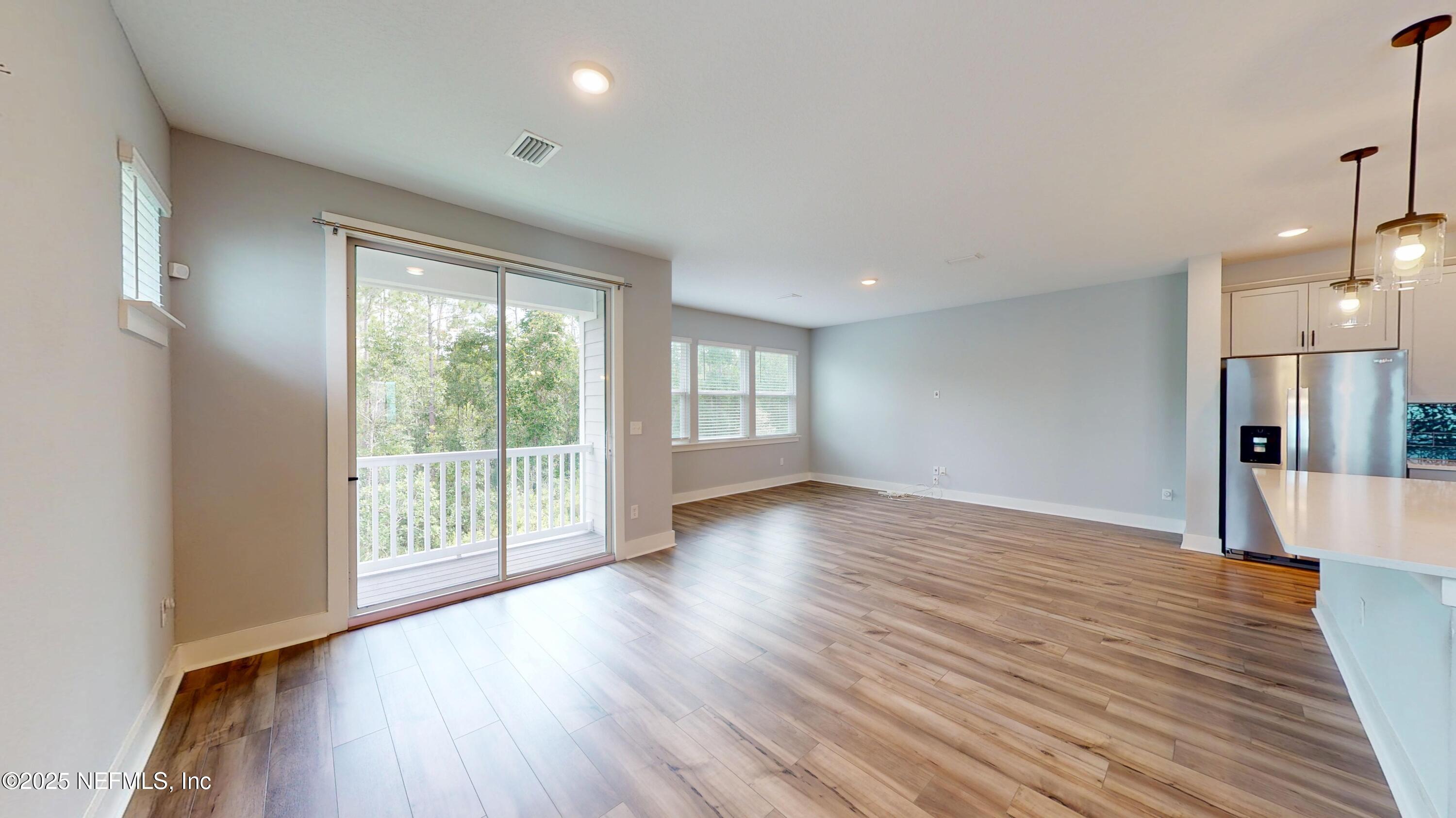 9921 Element Road Jacksonville, FL 32256 - Photo 4 of 37 a view of an empty room with wooden floor and a window