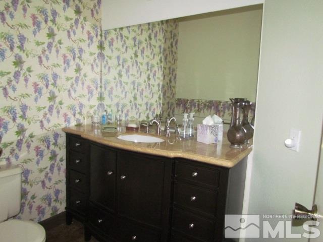 115 Cliff View Drive Reno, NV 89523 - Photo 10 of 25 a bathroom with a granite countertop sink a toilet and a mirror