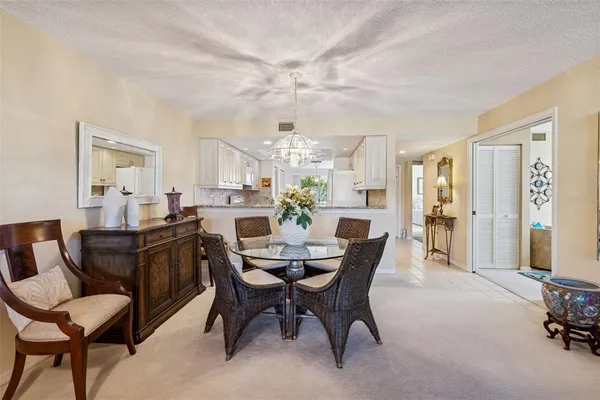 a living room with furniture a chandelier and a rug