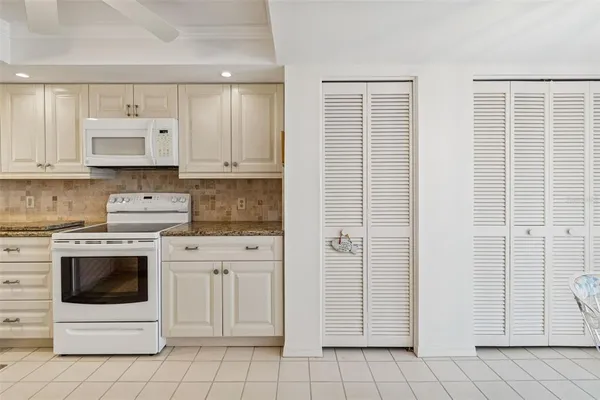 a kitchen with white cabinets and white appliances