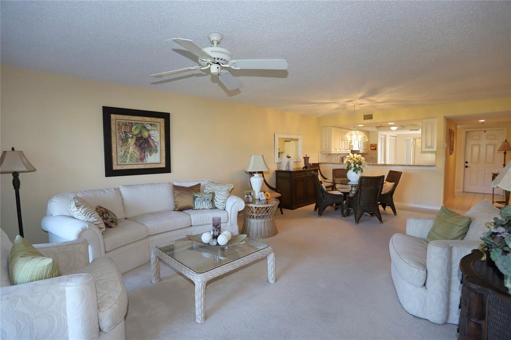 6707 Stone River Road, Unit 101 Bradenton, FL 34203 - Photo 7 of 34 a living room with furniture and a chandelier