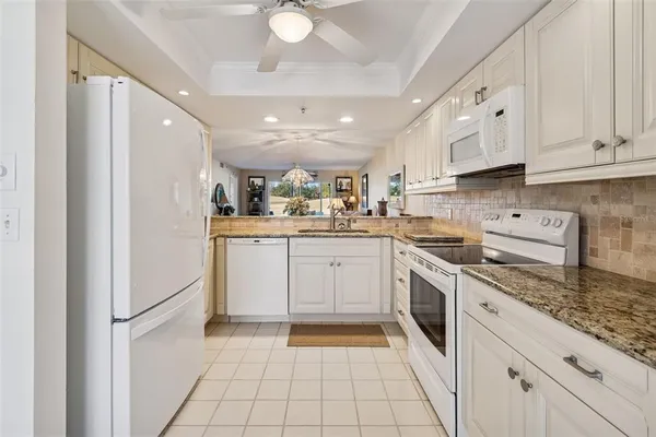 a kitchen with white cabinets appliances and a sink