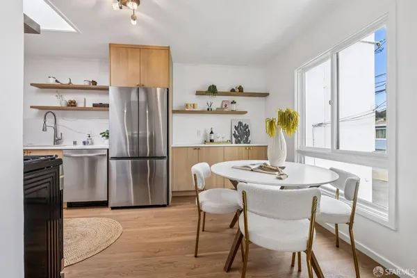a kitchen with stainless steel appliances granite countertop a refrigerator a stove a sink and a dining table