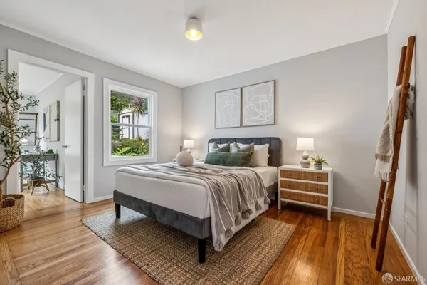 a bedroom with a bed and wooden floor