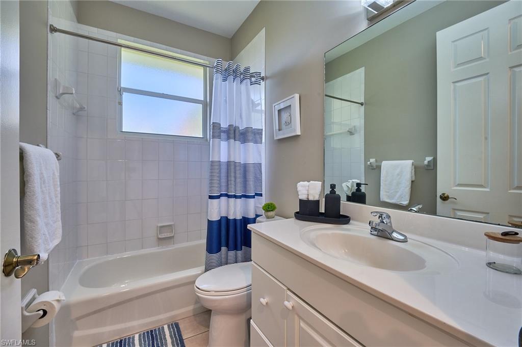 186 Muirfield Circle Naples, FL 34113 - Photo 24 of 36 a bathroom with a sink a toilet a tub and shower