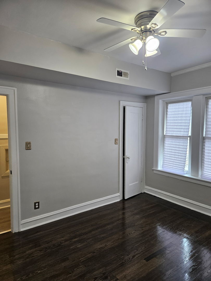 8309 South Throop Street, Unit 3 Chicago, IL 60620 - Photo 3 of 15 a view of an empty room with wooden floor and a window