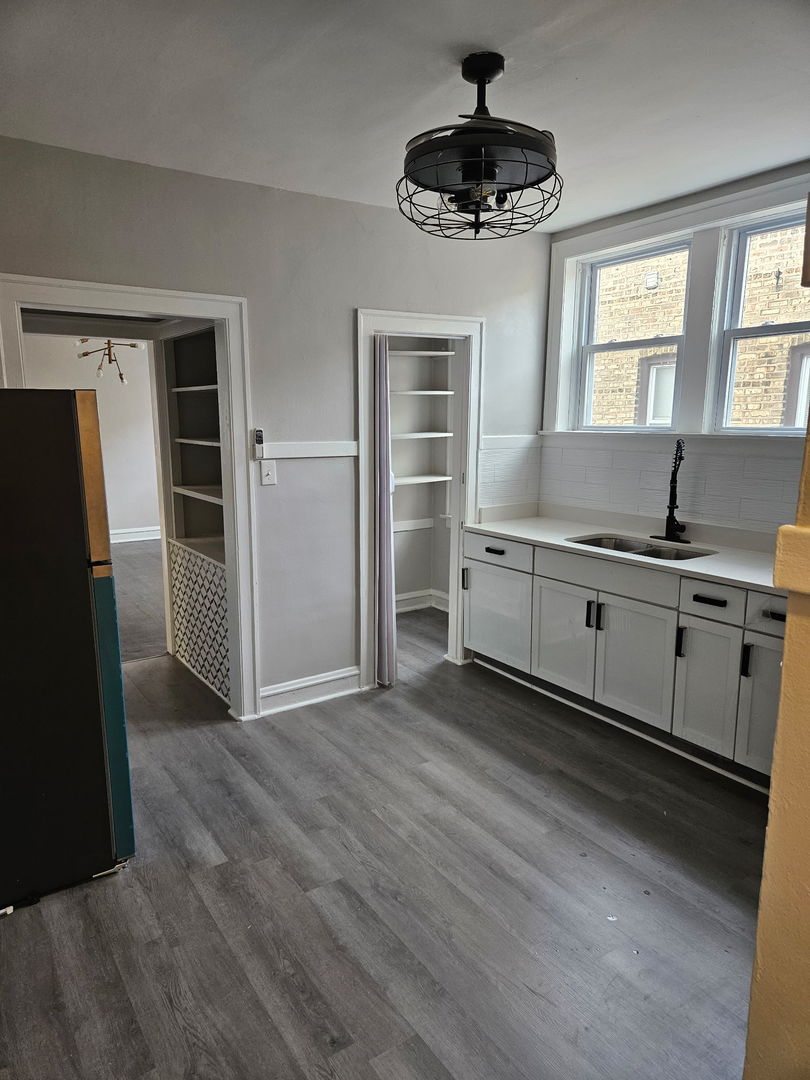 8309 South Throop Street, Unit 3 Chicago, IL 60620 - Photo 6 of 15 a kitchen with stainless steel appliances a sink cabinets and wooden floor
