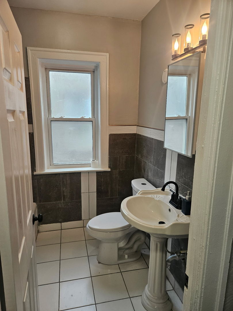 8309 South Throop Street, Unit 3 Chicago, IL 60620 - Photo 9 of 15 a bathroom with a sink a toilet and mirror