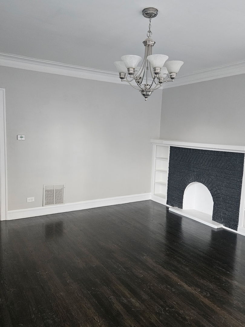 8309 South Throop Street, Unit 3 Chicago, IL 60620 - Photo 10 of 15 a view of a room with wooden floor and chandelier