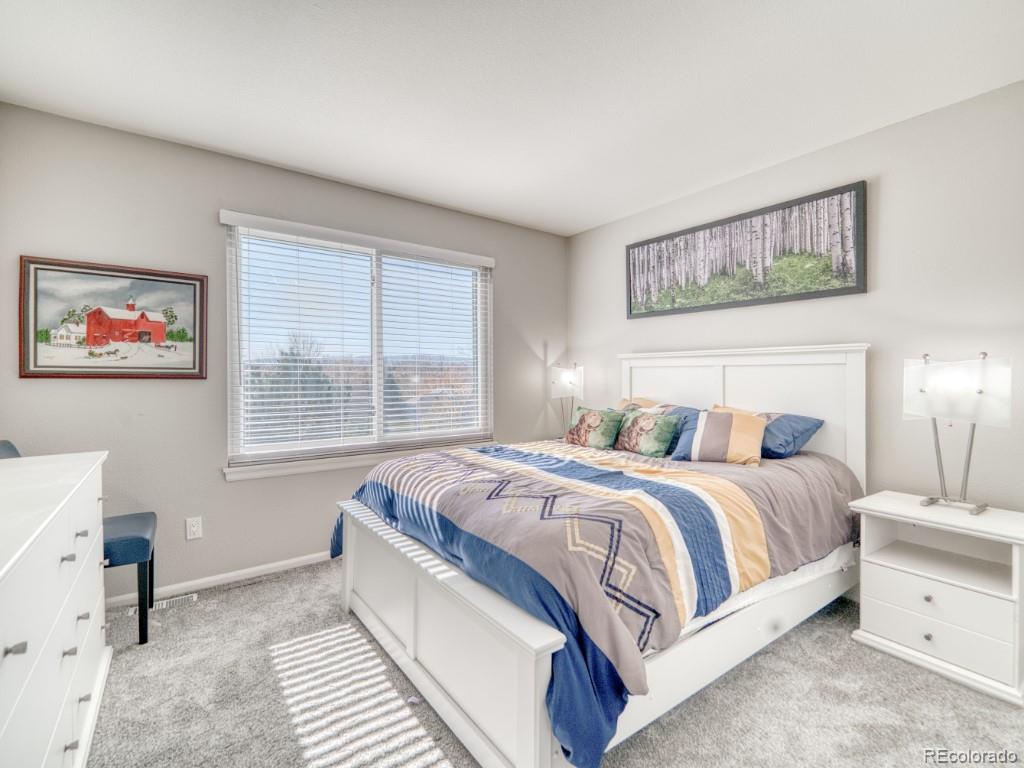 1864 Mountain Maple Avenue Highlands Ranch, CO 80129 - Photo 25 of 35 a spacious bedroom with a large bed and a window