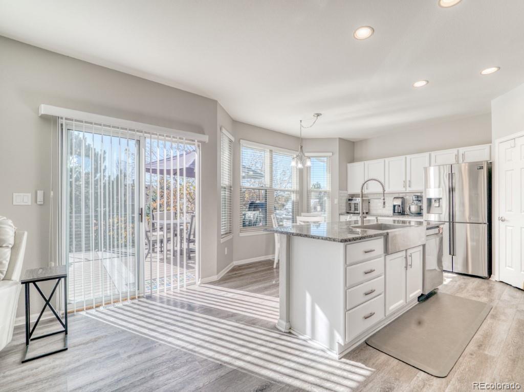 1864 Mountain Maple Avenue Highlands Ranch, CO 80129 - Photo 7 of 35 a kitchen with granite countertop white cabinets and refrigerator