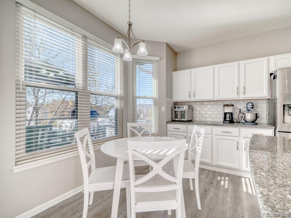 1864 Mountain Maple Avenue Highlands Ranch, CO 80129 - Photo 8 of 35 a kitchen with stainless steel appliances granite countertop a stove a refrigerator and white cabinets with wooden floor