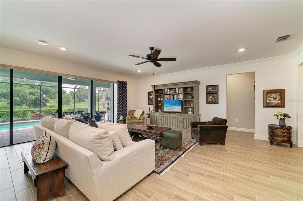 16341 Hidden Oak Loop Lakewood Ranch, FL 34211 - Photo 11 of 76 a living room with furniture a large window with wooden floor