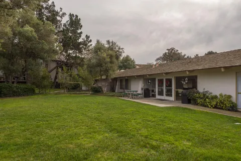a front view of house with yard barbeque and outdoor seating