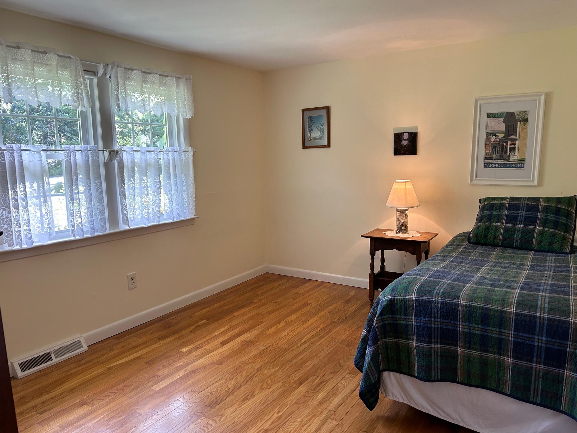 5 Acorn Road Dennis, MA 02638 - Photo 15 of 27 a bedroom with a bed and wooden floor