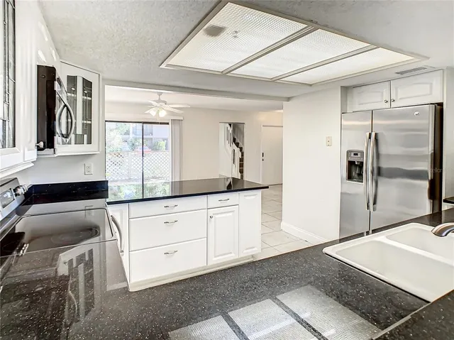 a kitchen with stainless steel appliances granite countertop a sink and a refrigerator