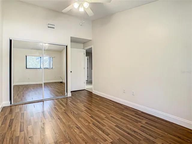 an empty room with wooden floor and windows