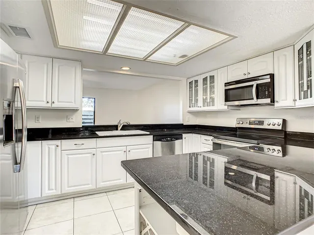 a kitchen with stainless steel appliances granite countertop a sink stove and microwave