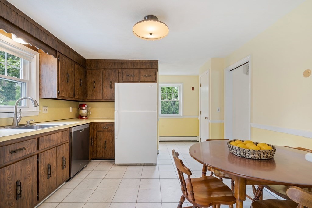 12 Lansdowne Road Arlington, MA 02474 - Photo 8 of 26 a kitchen with a refrigerator a stove a sink and a dining table