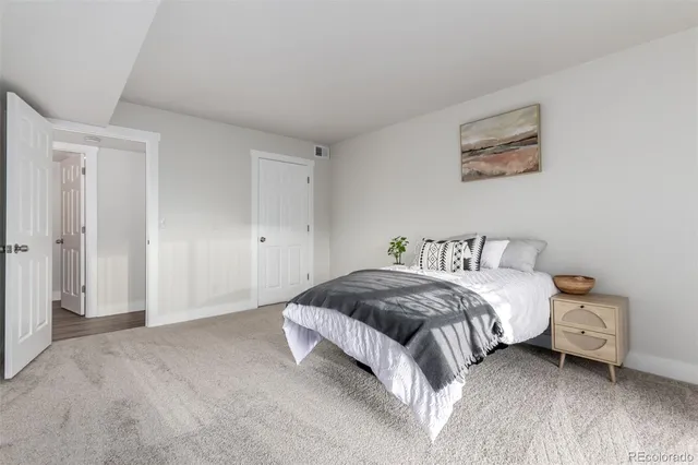 a bedroom with a bed and a painting on the wall