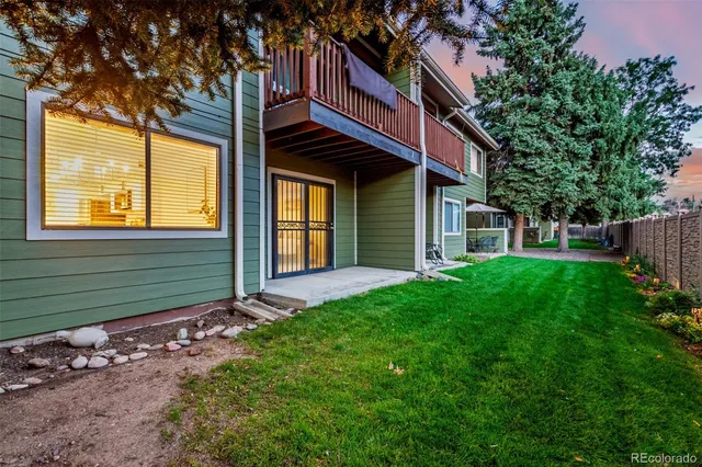 a view of a house with a yard and a large tree