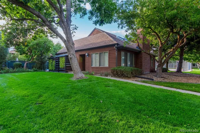 a backyard of a house with potted plants and large tree