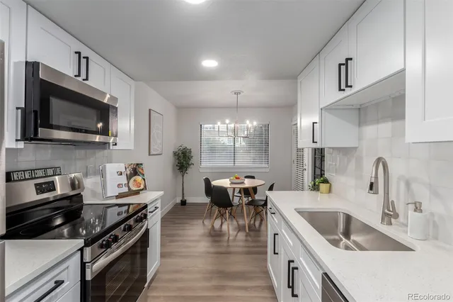 a kitchen with stainless steel appliances a stove sink microwave and cabinets