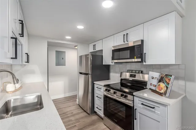 a kitchen with stainless steel appliances a sink a stove a microwave and refrigerator