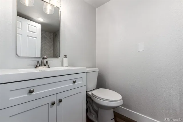 a bathroom with a sink mirror vanity and toilet