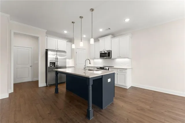 a kitchen with kitchen island stainless steel appliances a sink stove and refrigerator