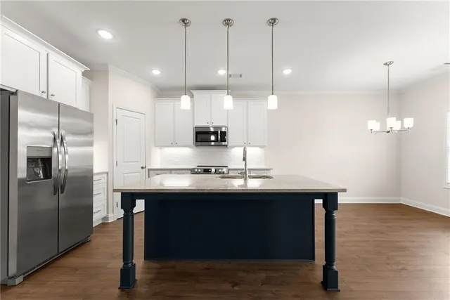 a kitchen with kitchen island a sink stainless steel appliances and wooden floor