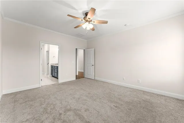 an empty room with chandelier fan and windows