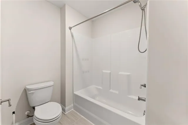a white toilet sitting next to a bath tub and a shower