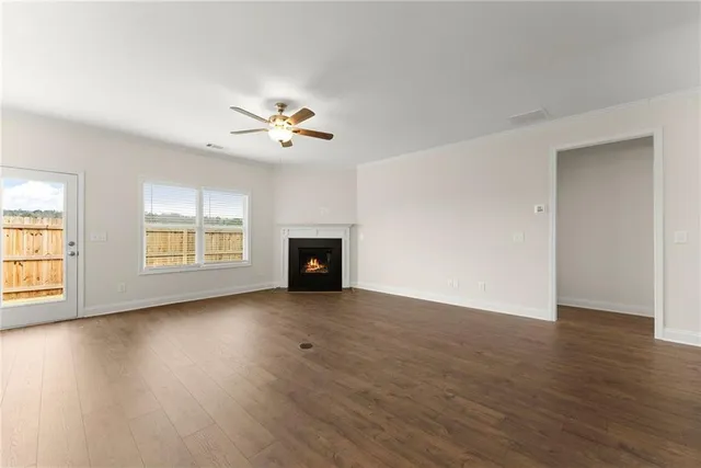 an empty room with wooden floor and chandelier fan