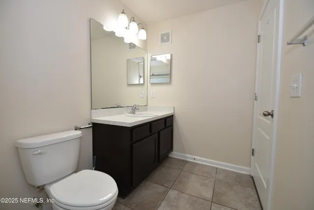 a bathroom with a sink vanity and a toilet