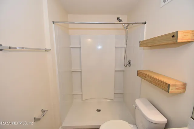 a bathroom with a toilet sink vanity and mirror