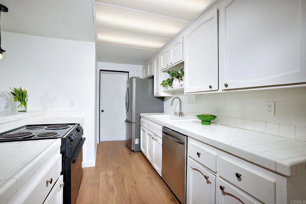 214 Calle De Madera Encinitas, CA 92024 - Photo 11 of 25 a kitchen with stainless steel appliances a white cabinets and a stove top oven
